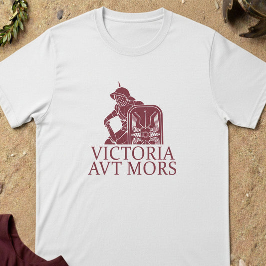 White gladiatort-shirt with red graphic and text on a sandy background