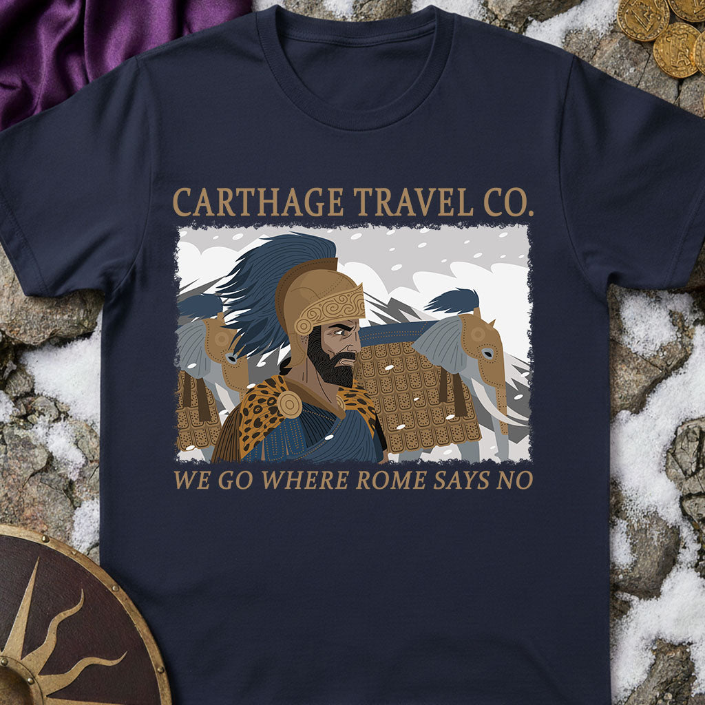 Navy blue t-shirt with Carthage Travel Co. graphic and text on a stone surface.