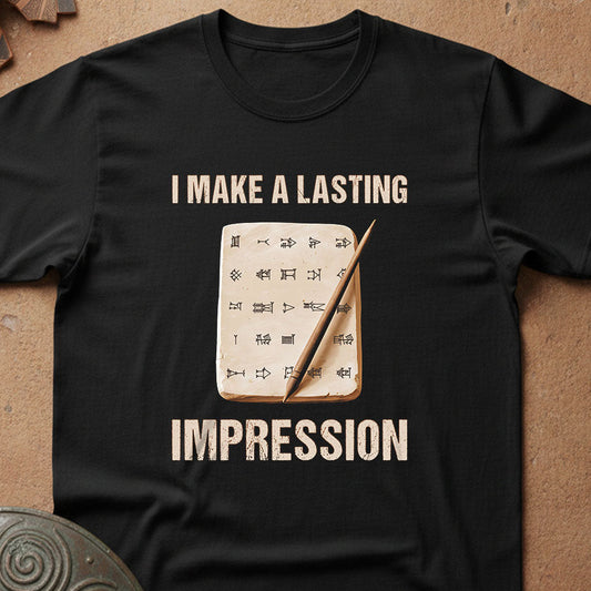 Black t-shirt with graphic design and text 'I Make a Lasting Impression' on a textured surface.