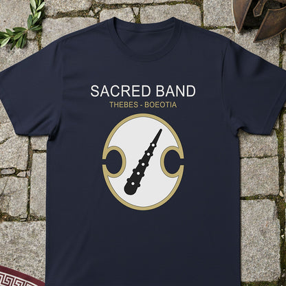 Navy blue t-shirt with 'Sacred Band Thebes Boeotia' design on a stone surface