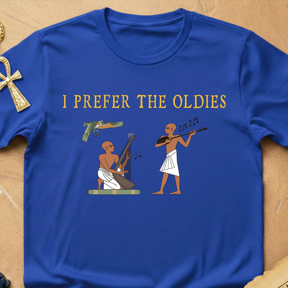 Blue t-shirt with Egyptian-themed design and text 'I Prefer the Oldies' on a wooden surface.