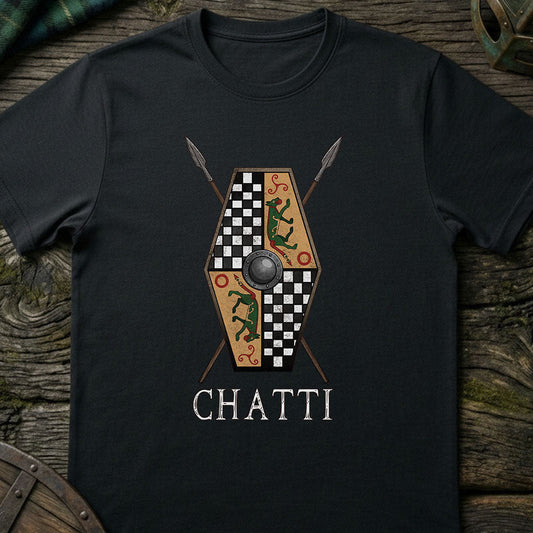Black t-shirt with a shield and spear design and 'CHATTI' text on a wooden surface.
