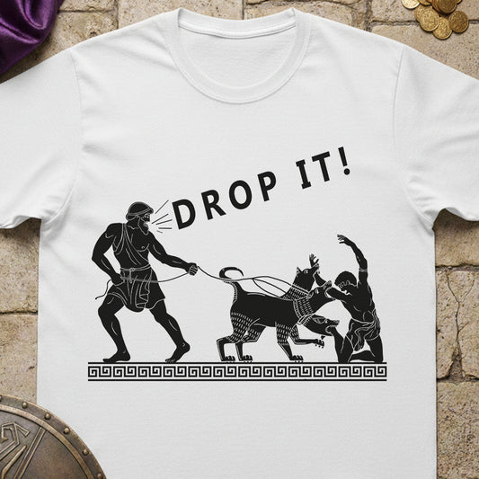 White t-shirt with black graphic design and 'DROP IT!' text on a stone surface.