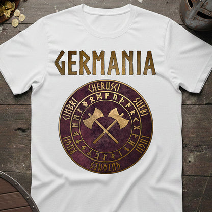 White t-shirt with 'GERMANIA' design featuring crossed axes and runes on a wooden surface.