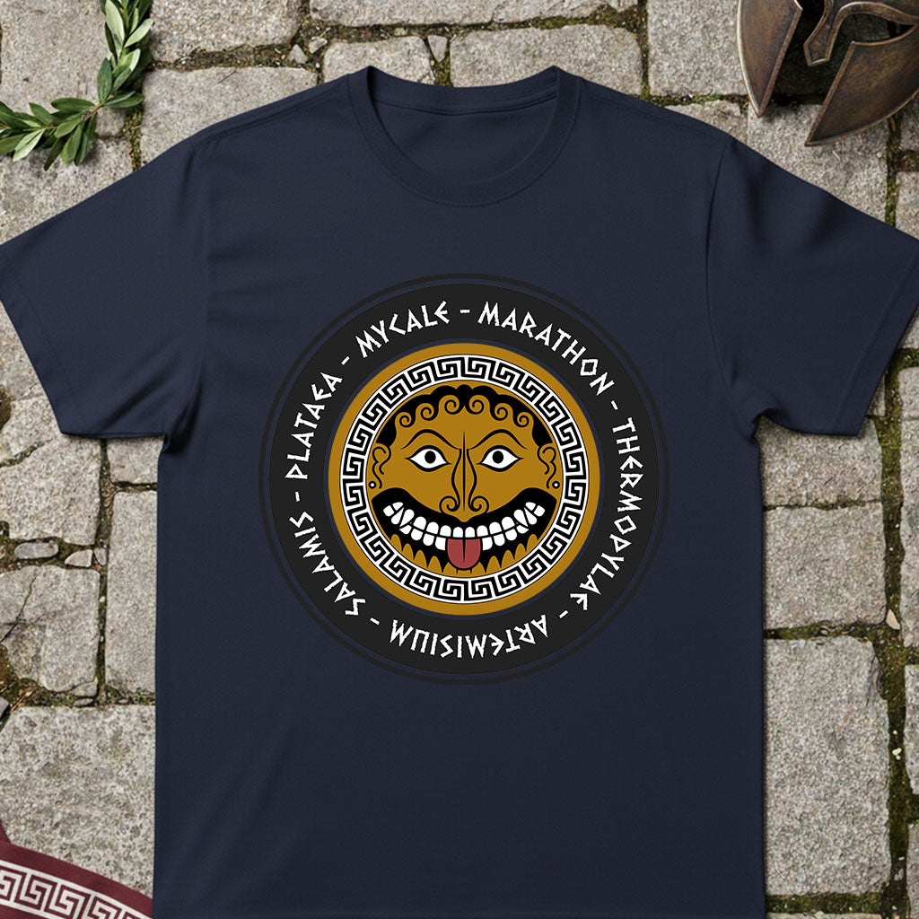 Navy blue t-shirt with a circular design featuring a greek gorgon and text on a stone surface.