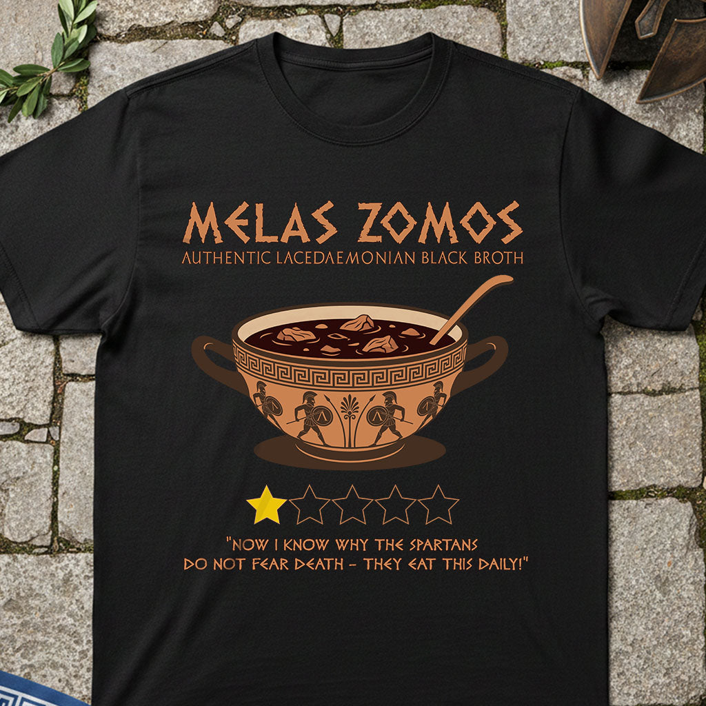 Black t-shirt with 'Melas Zomos' design featuring a bowl of soup on a stone surface.