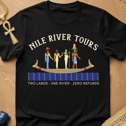 A black short-sleeve graphic t-shirt laid flat on a tan textured background. The shirt features a graphic of ancient Egyptian figures in a boat with text NILE RIVER TOURS