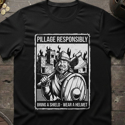 Black t-shirt with a Viking graphic and text on a wooden surface with coins and a helmet.