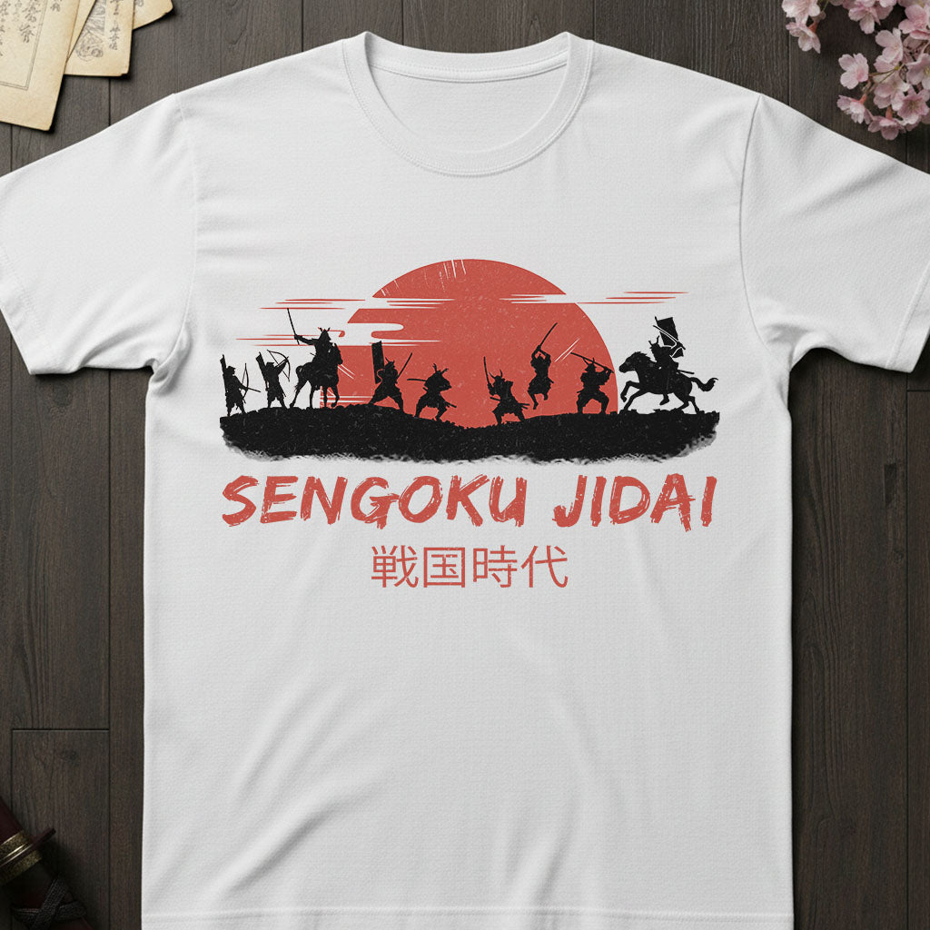 White t-shirt with 'Sengoku Jidai' design featuring silhouettes of samurai warriors and a red sun on a wooden surface.