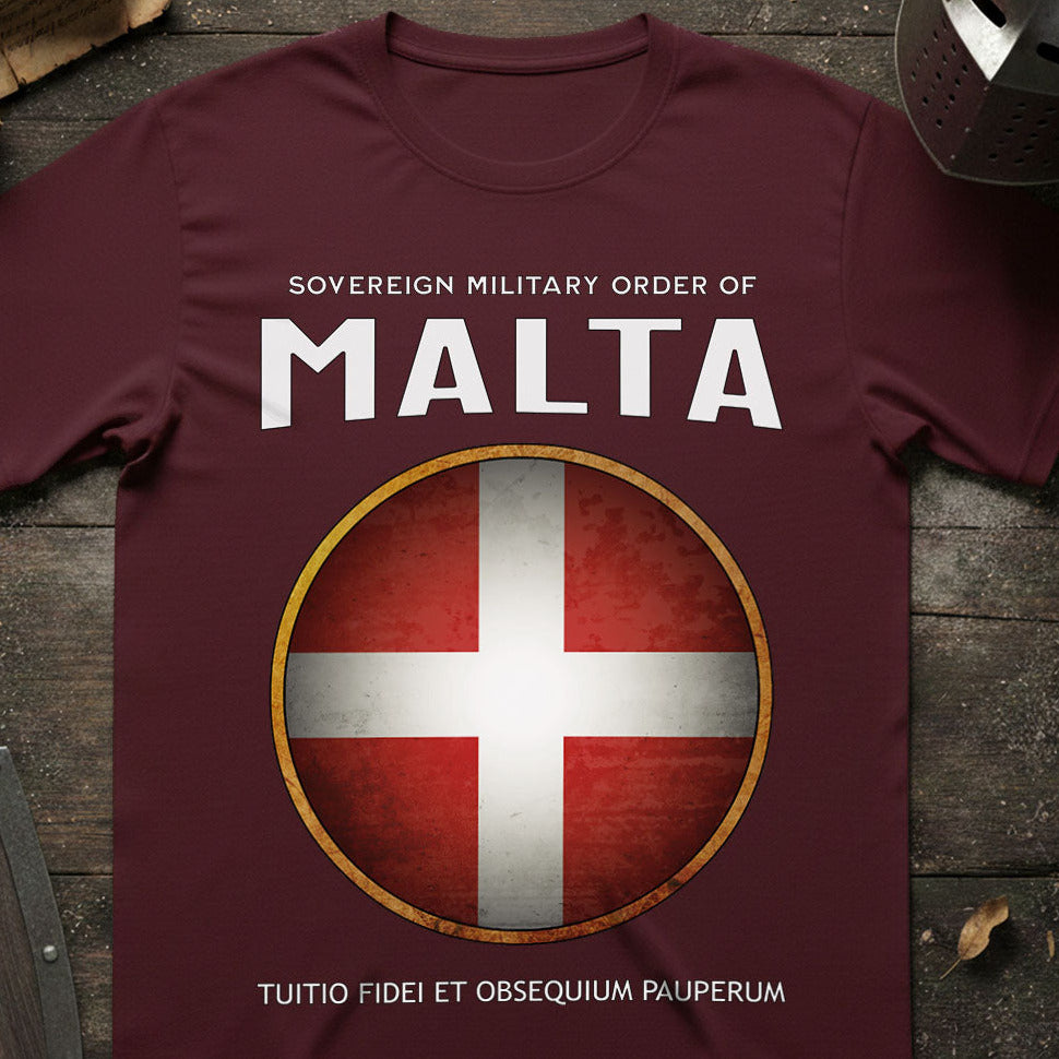 Maroon t-shirt with Sovereign Military Order of Malta logo on a wooden surface