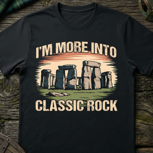 Black t-shirt with Stonehenge graphic and text 'I'm more into classic rock' on a wooden surface.