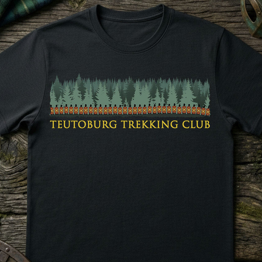 Black t-shirt with 'Teutoburg Trekking Club' design on a wooden surface