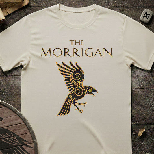White t-shirt with 'The Morrigan' design on a wooden surface