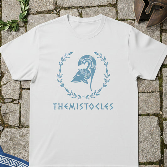 White t-shirt with blue graphic and 'THEMISTOCLES' text on a stone surface.