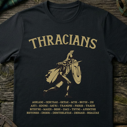 Black t-shirt with gold 'THRACIANS' text and warrior silhouette on a wooden surface.