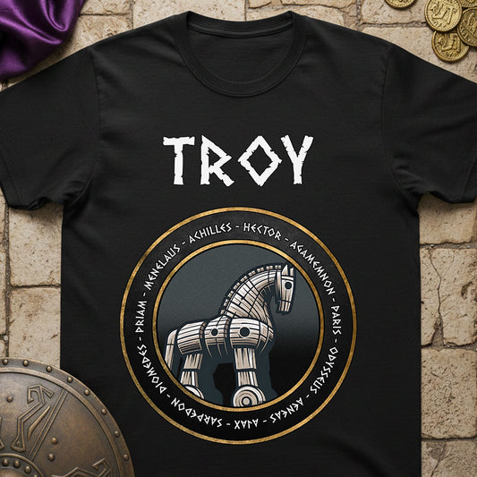 Black t-shirt with Trojan horse graphic and 'TROY' text on a stone surface with coins and fabric.