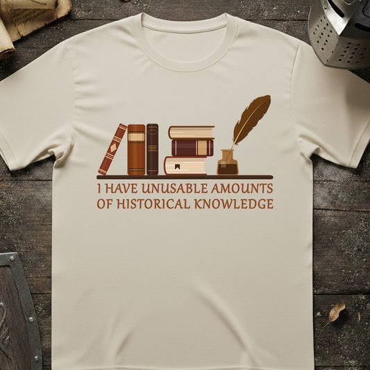 Beige t-shirt with books and quill design and text on a wooden surface