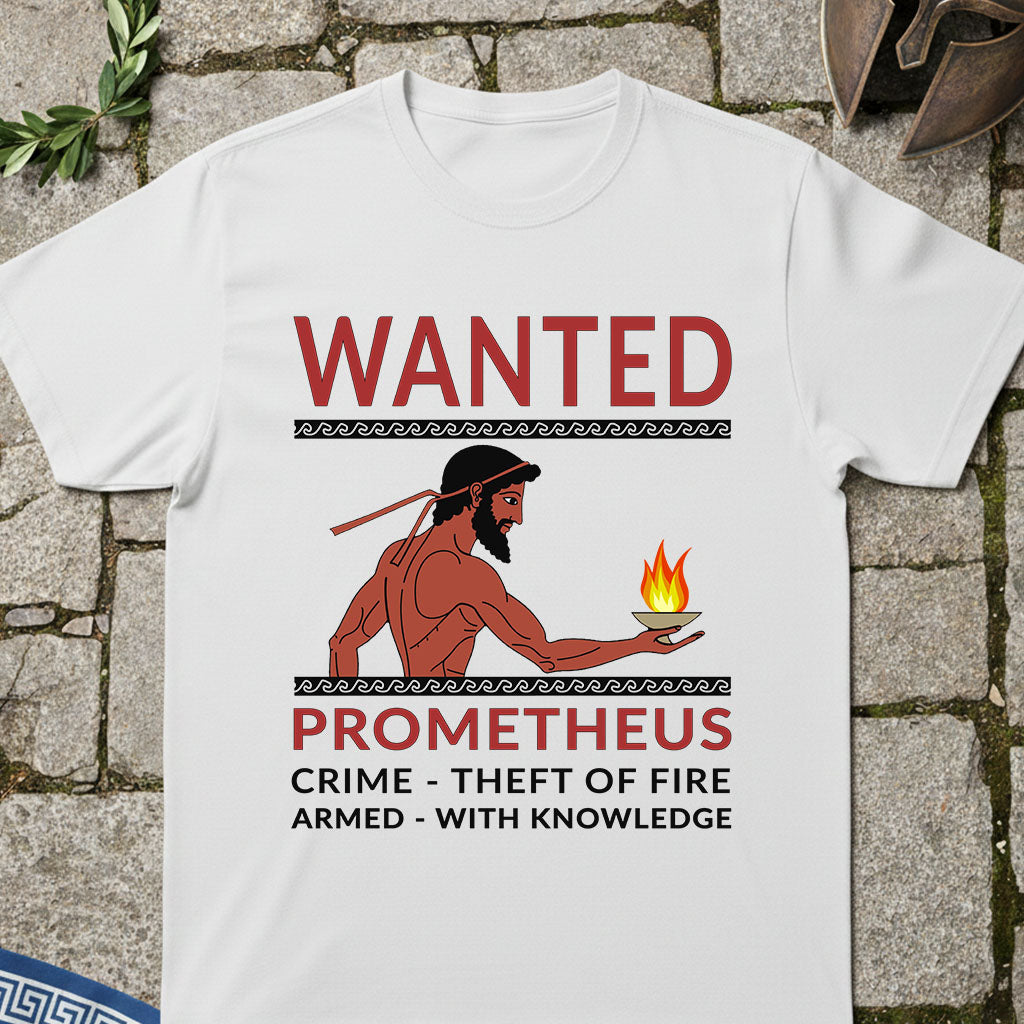 A white short-sleeve crewneck t-shirt featuring a graphic print of a 'Wanted' poster for Prometheus. The design includes a red and black illustration of Prometheus holding a fire, with text reading 'WANTED PROMETHEUS CRIME - THEFT OF FIRE ARMED - WITH KNOWLEDGE'.