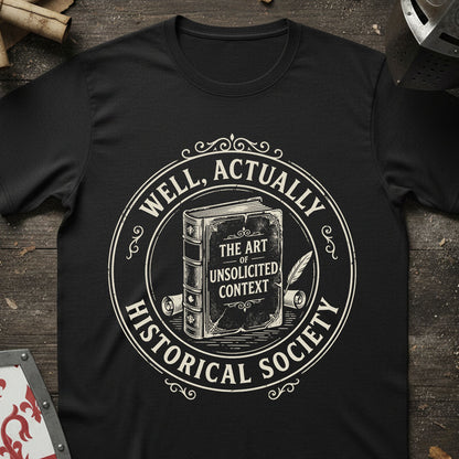 Black t-shirt with white graphic design Well Actually Historical Society T-shirt on a wooden surface