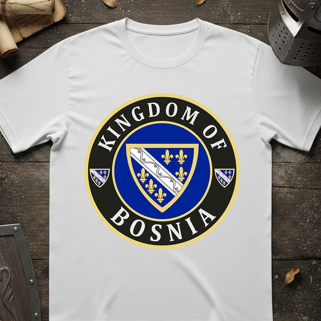 White t-shirt with 'Kingdom of Bosnia' emblem design on a wooden surface.