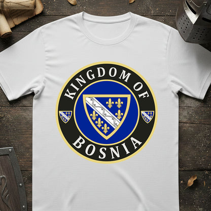 White t-shirt with 'Kingdom of Bosnia' emblem design on a wooden surface.