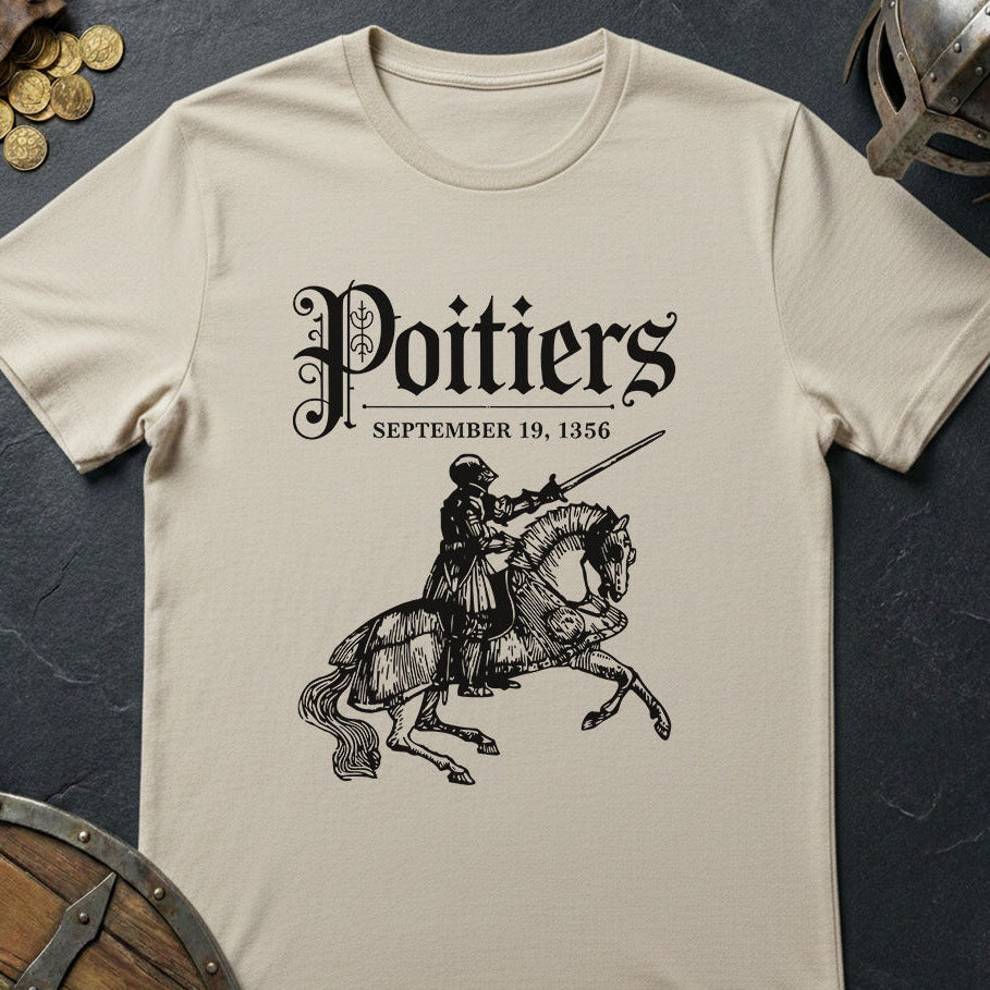 Beige t-shirt with a graphic of a knight on a horse and text 'Poitiers September 19, 1356' on a dark surface.