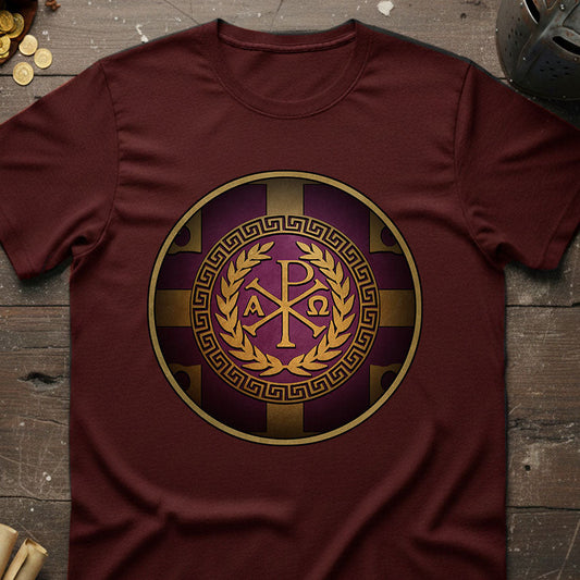 Byzantine Maroon t-shirt with a gold and purple emblem on a wooden surface.
